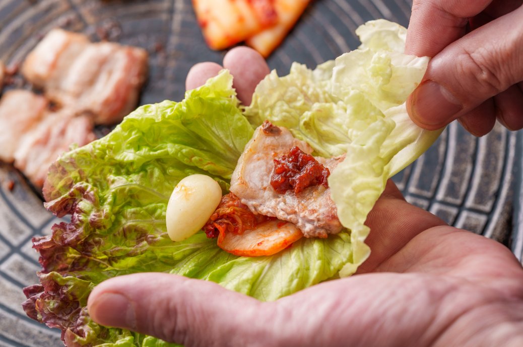 サムギョプサルをチシャで包む様子